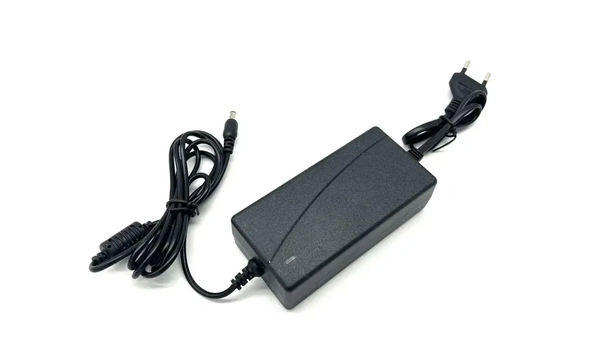 Schwarzes Netzteil mit Kabeln und Stecker, 12V 5A Leistung.