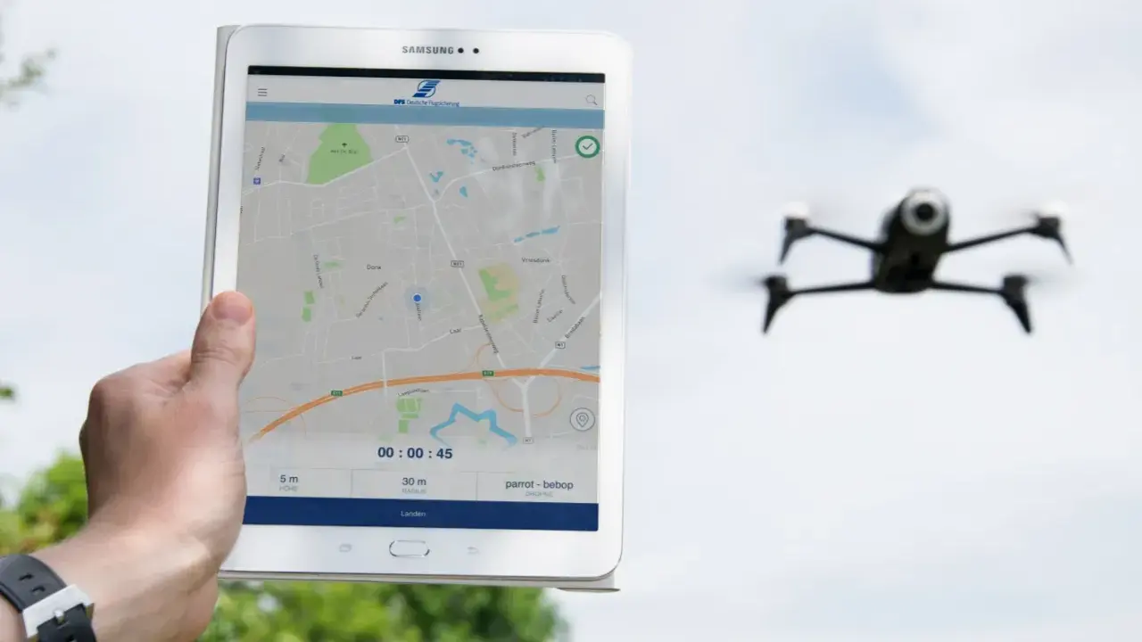 Tablet zeigt eine Karte und Drohnen-Apps. Eine Drohne fliegt im Hintergrund.