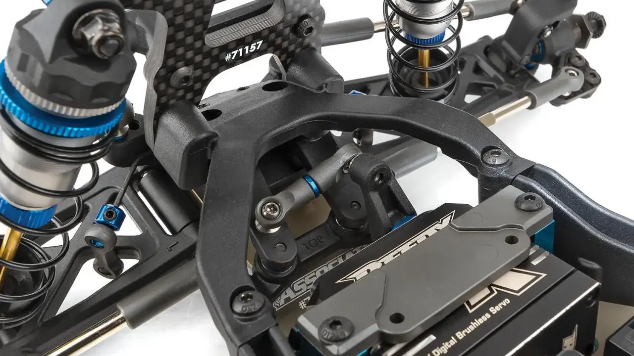 Detailaufnahme des Fahrwerks eines RC-Autos. Stoßdämpfer, Carbonteile und ein HV Digital Brushless Servo sind sichtbar. Die Nummer #71157 ist auf einem Teil eingraviert.