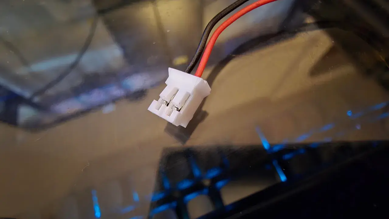 Ein weißer jst bec stecker mit roten und schwarzen Kabeln, bereit für den Anschluss.