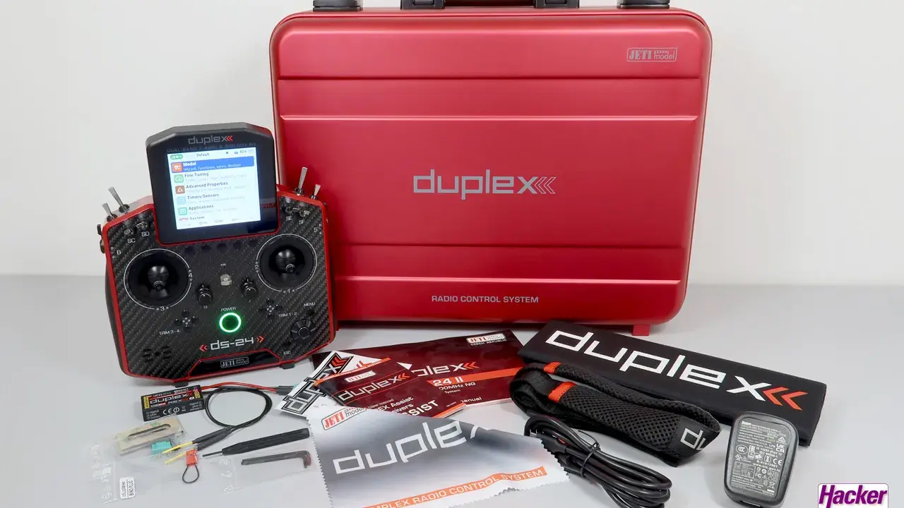Ein roter Koffer mit "duplex" Schriftzug und ein Jeti DS-24 Sender mit Zubehör.