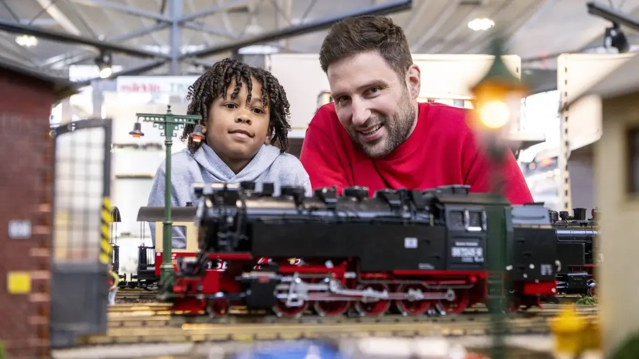 Vater und Sohn bestaunen detailreiche Modelleisenbahnen auf der Modellbaumesse Dortmund.