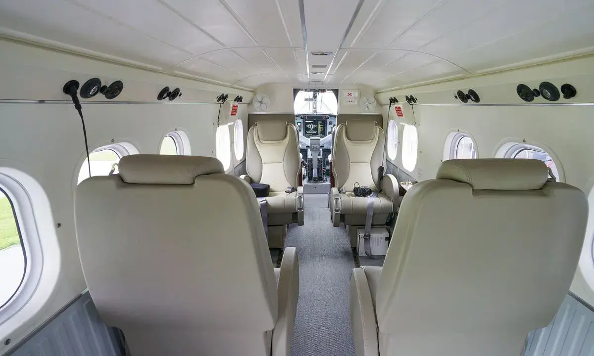 Innenraum einer DHC-6 Twin Otter mit bequemen Ledersitzen und Blick auf das Cockpit.
