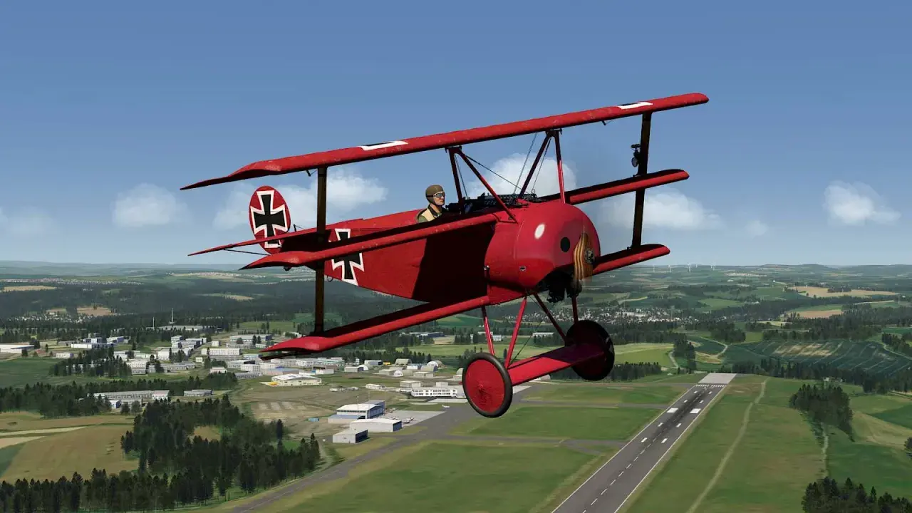 Ein rotes Fokker-Flugzeug mit Eisernem Kreuz fliegt über eine grüne Landschaft mit einer Stadt und einem Flugfeld.