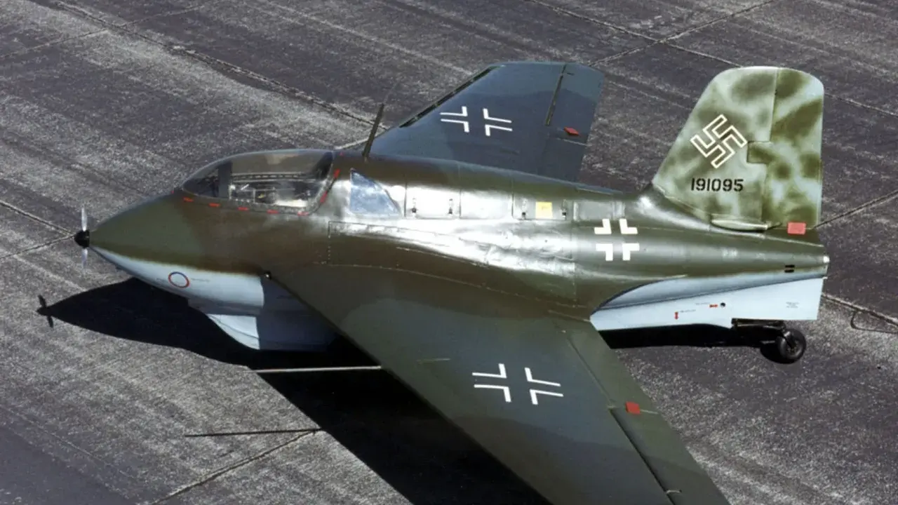 Ein Messerschmitt Me 163 Komet, ein Raketenjäger, steht auf einem Flugplatz.