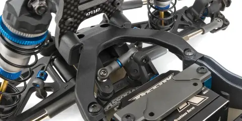 Detailaufnahme des Fahrwerks eines RC-Autos. Stoßdämpfer, Carbonteile und ein HV Digital Brushless Servo sind sichtbar. Die Nummer #71157 ist auf einem Teil eingraviert.