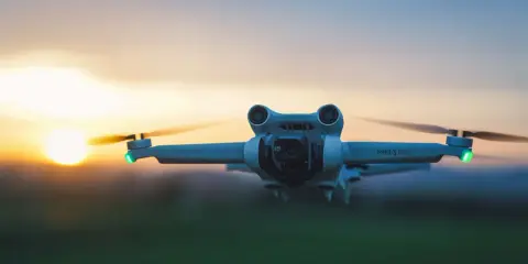 Eine Drohne fliegt im Abendlicht über ein Feld in Spanien.