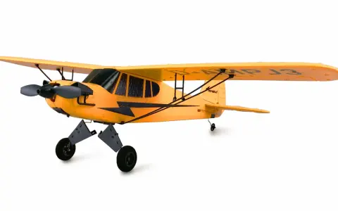 Ein gelbes Piper Flugzeug mit schwarzem Propeller und Fahrwerk steht auf weißem Grund.