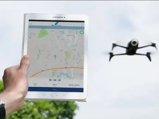 Tablet zeigt eine Karte und Drohnen-Apps. Eine Drohne fliegt im Hintergrund.
