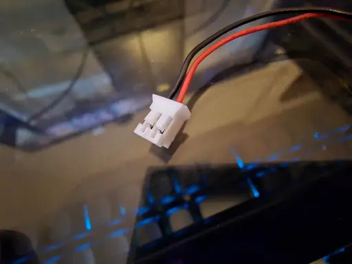 Ein weißer jst bec stecker mit roten und schwarzen Kabeln, bereit für den Anschluss.