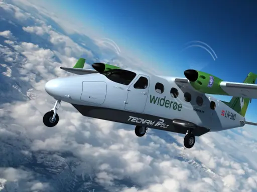Ein zweimotoriges Flugzeug mit dem Schriftzug "widerøe" und "TECNAM VOLT" fliegt über Wolken. Dies ist ein Beispiel für zukünftige Elektroflugzeuge.