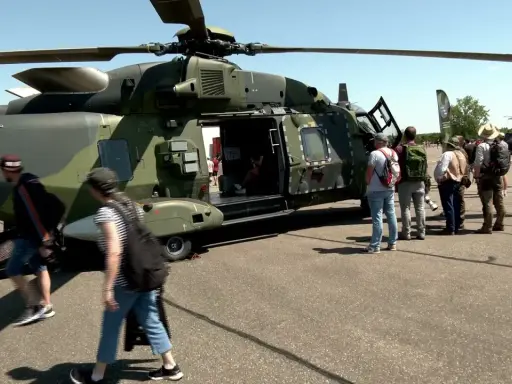 Besucher bestaunen deutsche Hubschrauber auf einem Flugplatz.