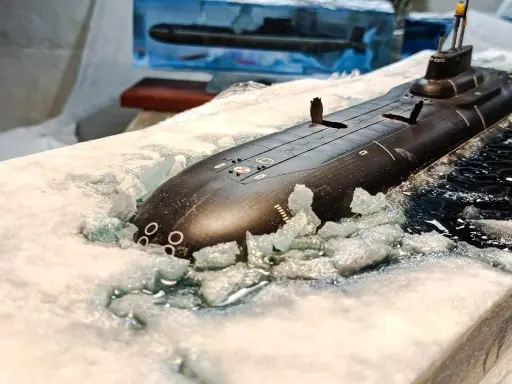 Ein Modell eines U-Bootes Akula bricht durch Eis und Wasser.