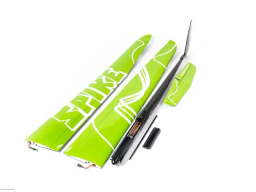 Grüne Flügelteile eines Modellflugzeugs mit weißer Schrift. Ein schwarzer Rumpf mit geöffnetem Batteriefach und 18 AWG Kabeln liegt daneben.