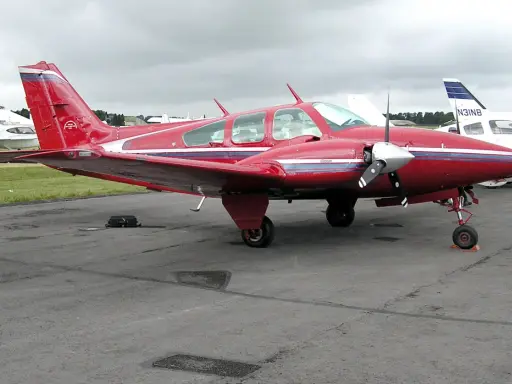 Roter Beechcraft Baron mit zwei Propellern auf dem Flugplatz.
