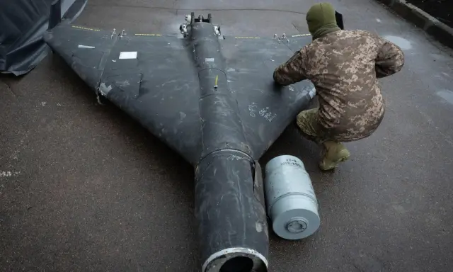 Ein Soldat inspiziert eine Drohne in Rumänien. Daneben liegt eine Munitionshülse.