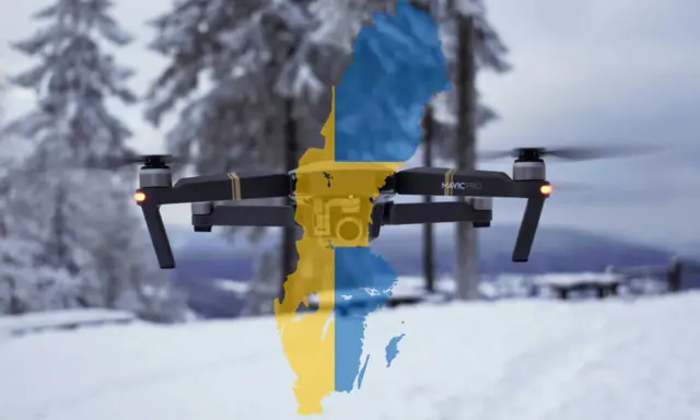 Eine Drohne mit der schwedischen Flagge fliegt über eine verschneite Landschaft.