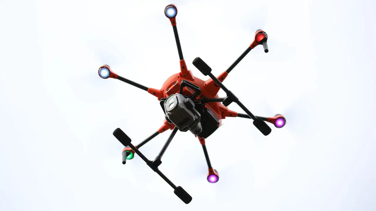 Ein Yuneec H520E Hexacopter mit Kamera schwebt vor einem hellen Himmel.