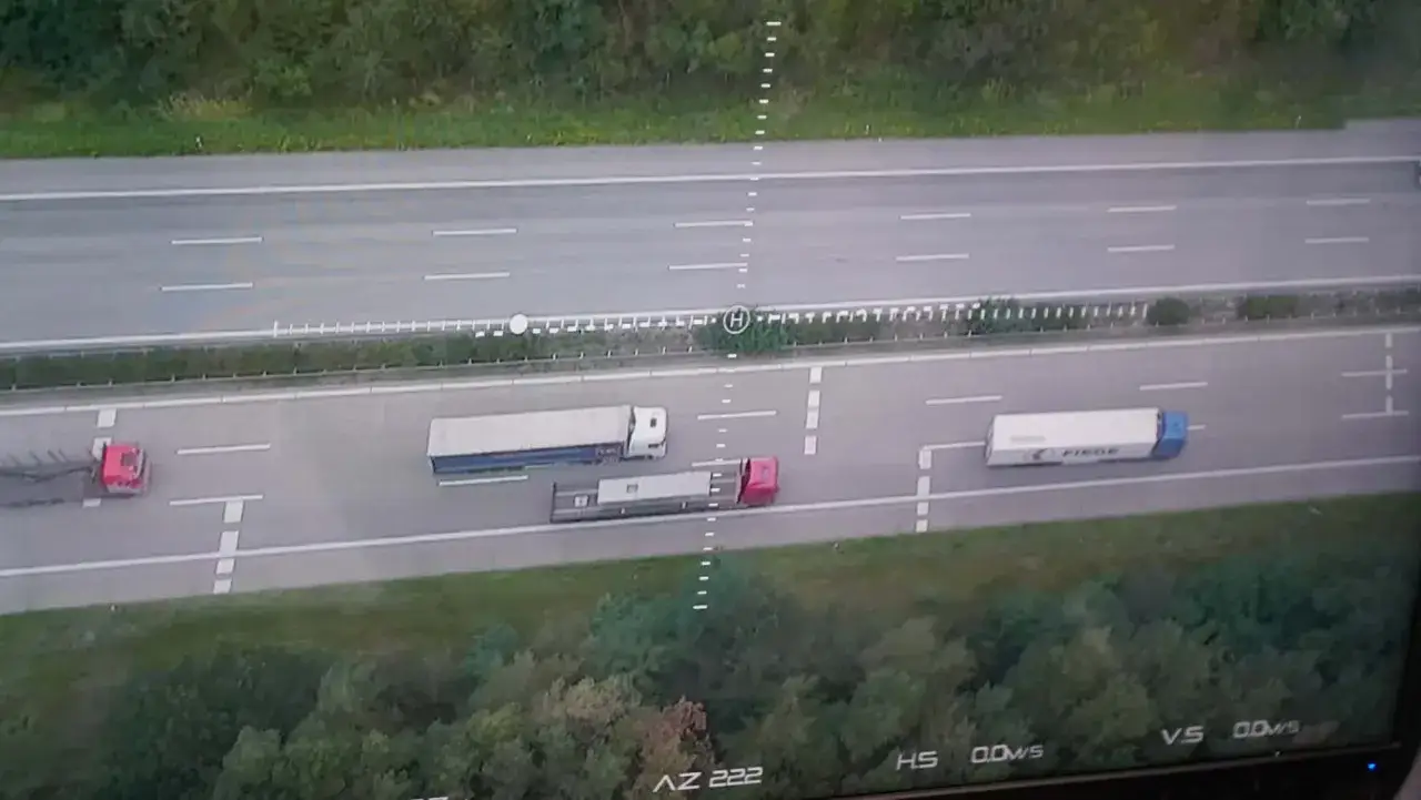 Drohne überwacht den Abstand zwischen LKW auf der Autobahn. Mehrere Sattelzüge sind auf der Fahrbahn zu sehen.