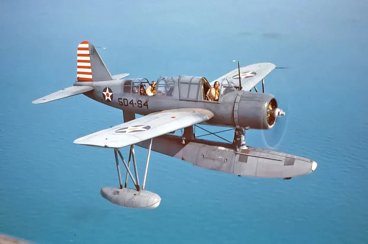 Ein Marchetti-Flugzeug mit zwei Piloten fliegt über das Meer.