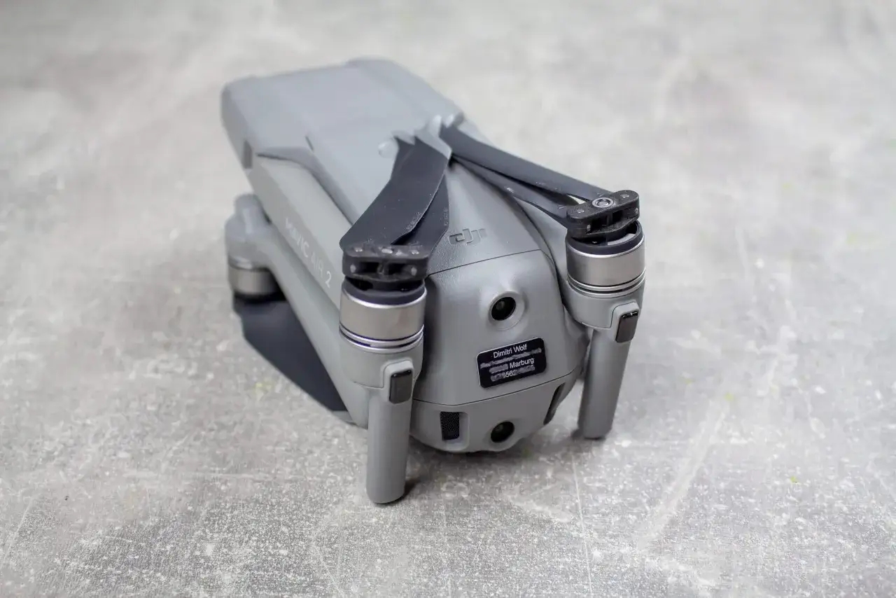 Grauer DJI Mavic Air 2 Drohne mit Propellern. Ein Aufkleber mit dem Namen 