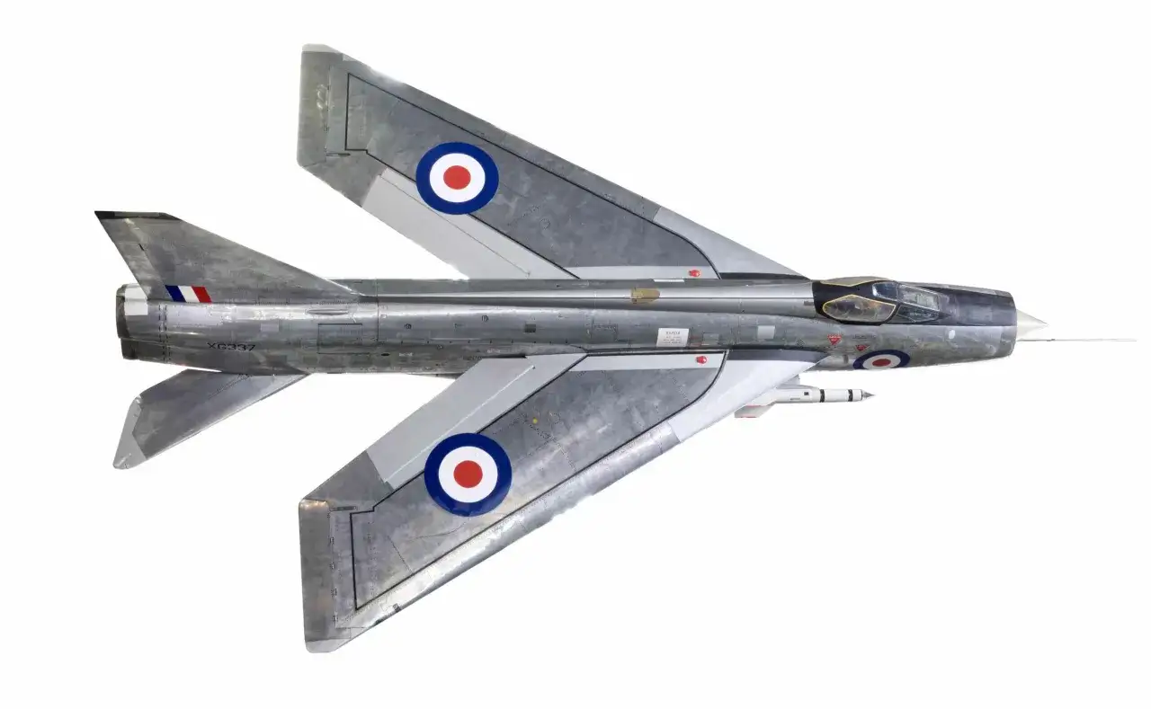 Ein silbernes Lightning Flugzeug mit britischen Markierungen und einer Rakete unter dem Flügel, bereit zum Abheben.