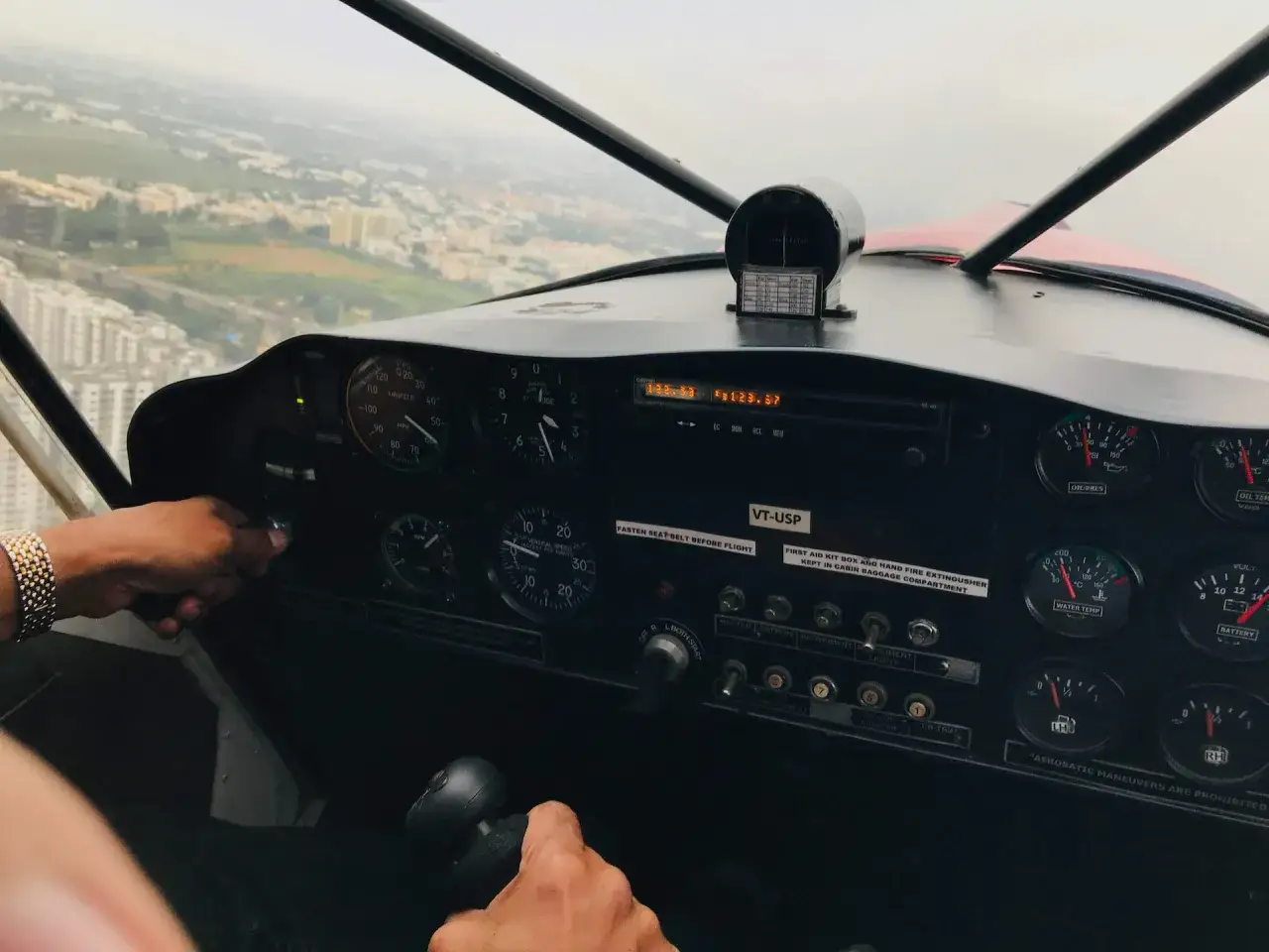 Blick ins Cockpit eines Ultraleichtflugzeugs. Hände am Steuer, Anzeigen für Geschwindigkeit und Höhe. Modelle von Ultraleichtflugzeugen sind hier im Einsatz.