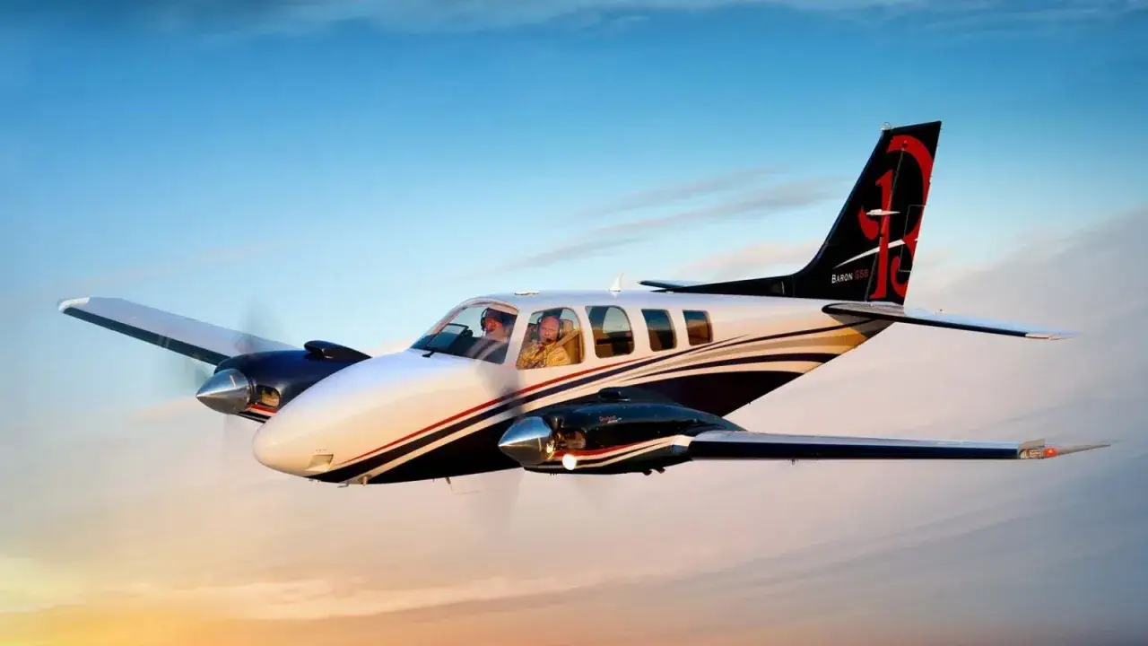 Zwei Piloten fliegen eine Beechcraft Baron G58 im Abendlicht.