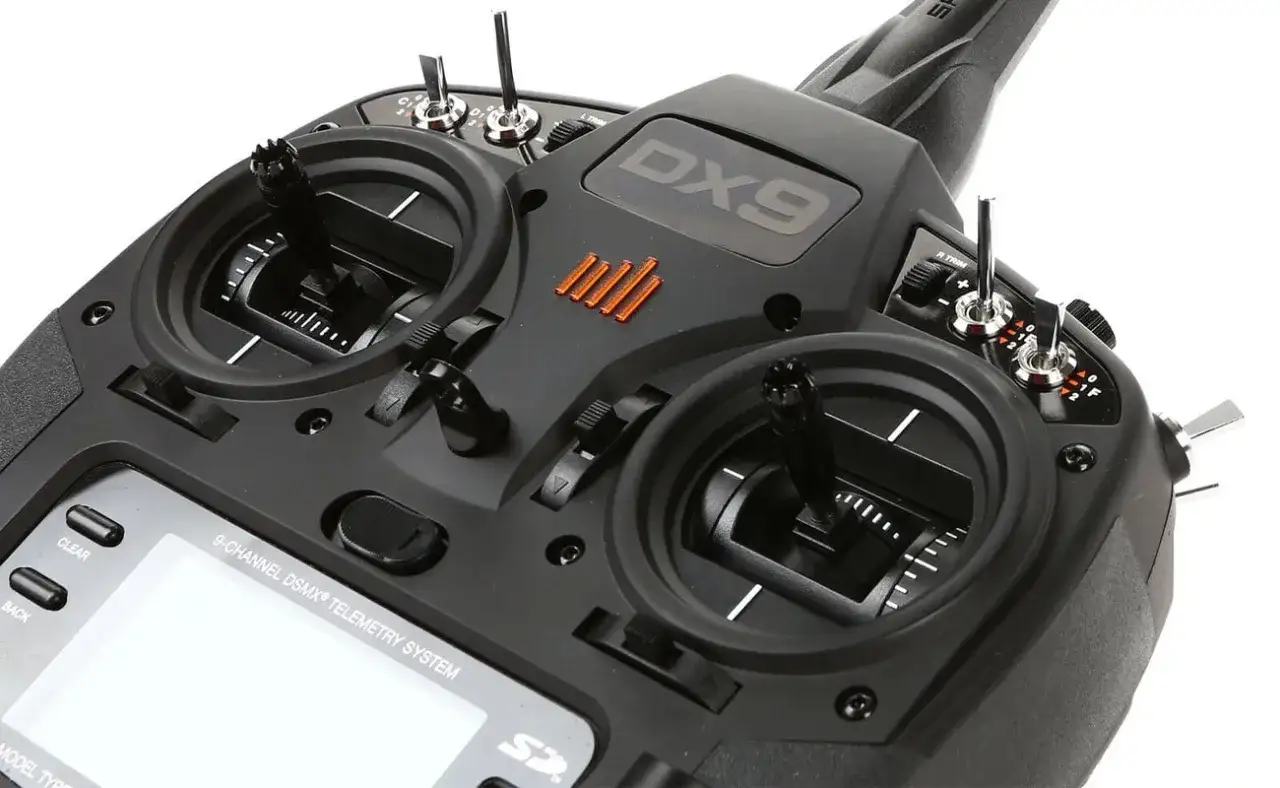 Ein schwarzer DX9-Sender mit zwei Joysticks und vielen Schaltern, bereit für den nächsten radiolink-Flug.