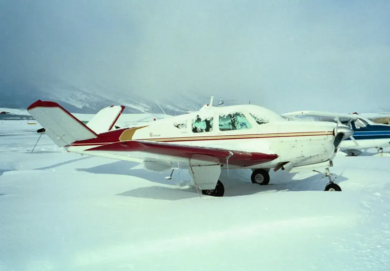 Eine Beechcraft Bonanza, bedeckt mit Schnee, wartet auf besseres Wetter.