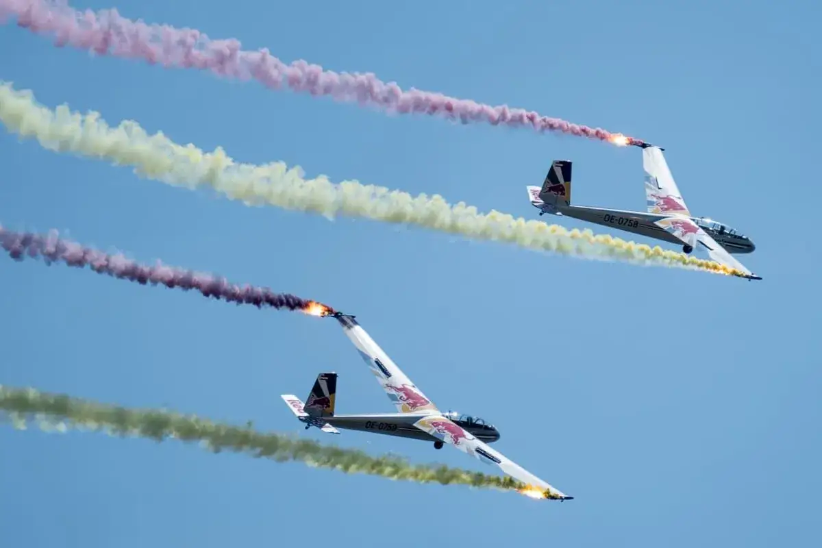Zwei Segelflugzeuge ziehen bunte Rauchschwaden bei einer Flugshow in Deutschland.